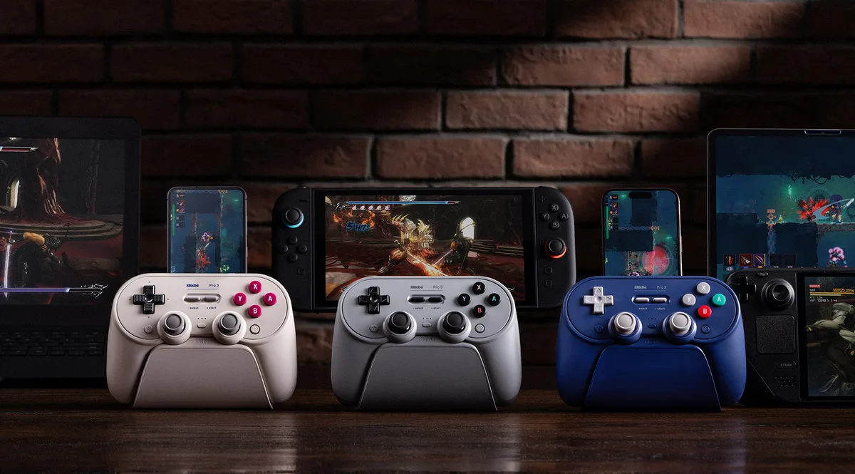 8BitDo Pro 3 controllers on charging docks with a Switch, Steam Deck, PC and tablets