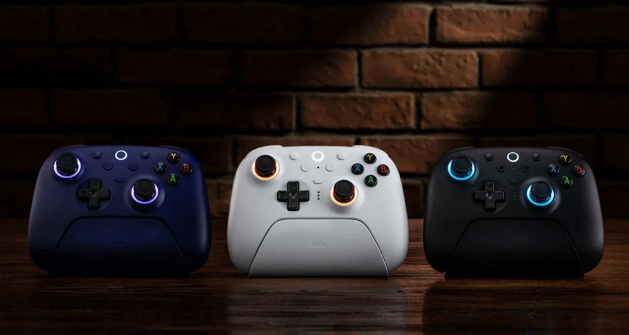 Three 8BitDo Ultimate 2 controllers in blue, white and black sitting in their charging docks