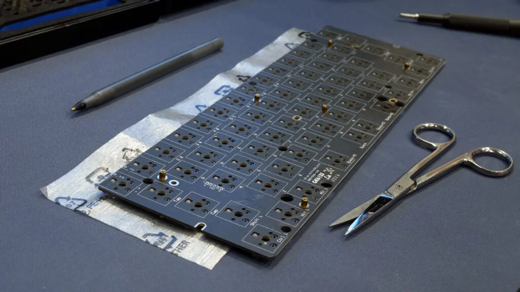 PE foam sheet marked to the PCB size with a pen and scissors ready to cut