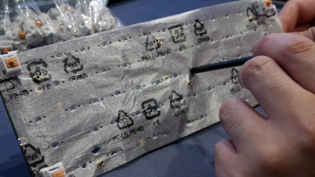 Poking holes in PE foam over the keyboard PCB switch sockets