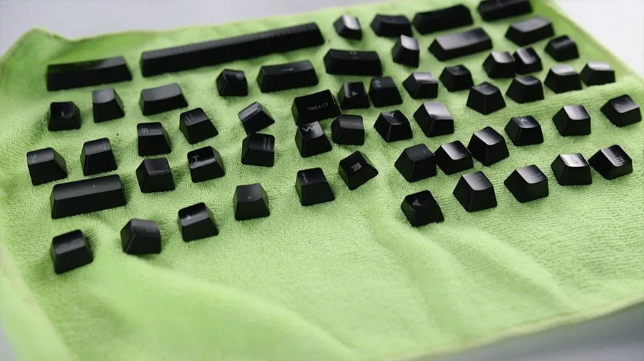 Clean keycaps laid out to air dry on a green microfiber towel