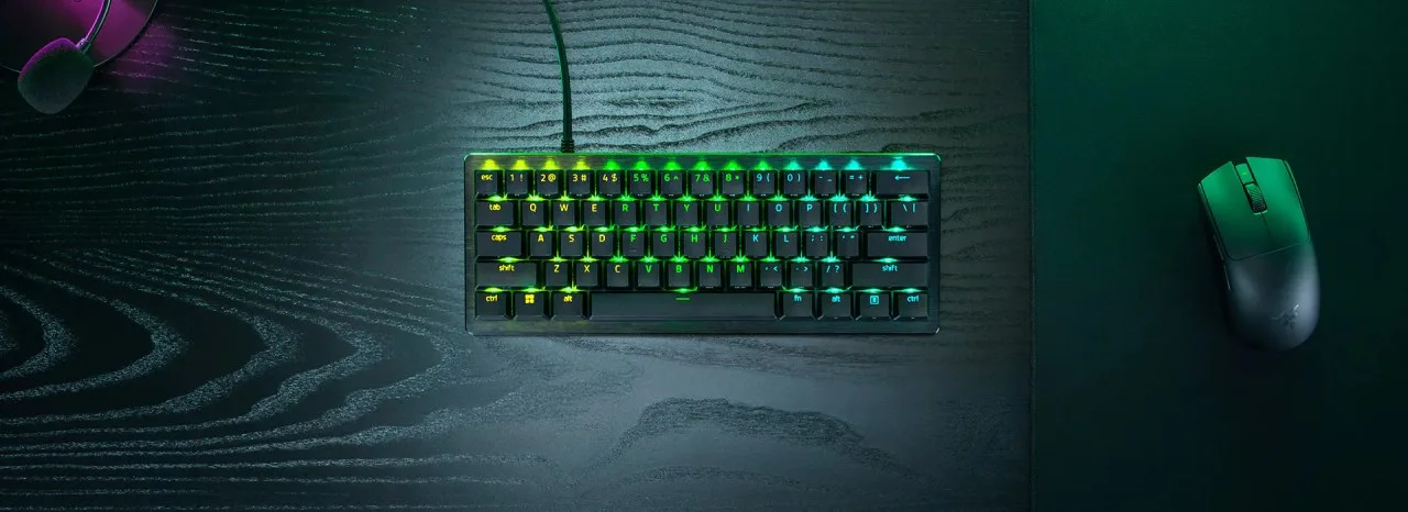 Razer Huntsman V3 Pro Mini 8KHz 60% keyboard on a desk next to a gaming mouse