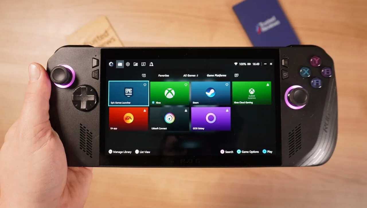 ASUS ROG Ally X held in one hand with Armoury Crate on screen