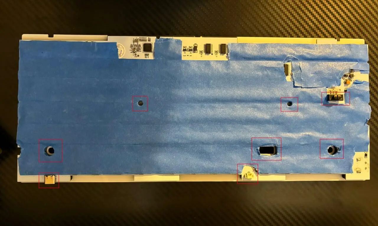 Keyboard PCB covered in painter's tape with screw holes, switch and connectors left uncovered