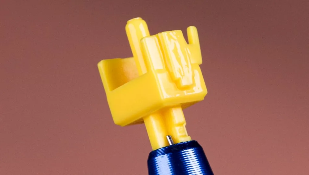 Yellow switch stem with a thin glossy coat of lube on its sides