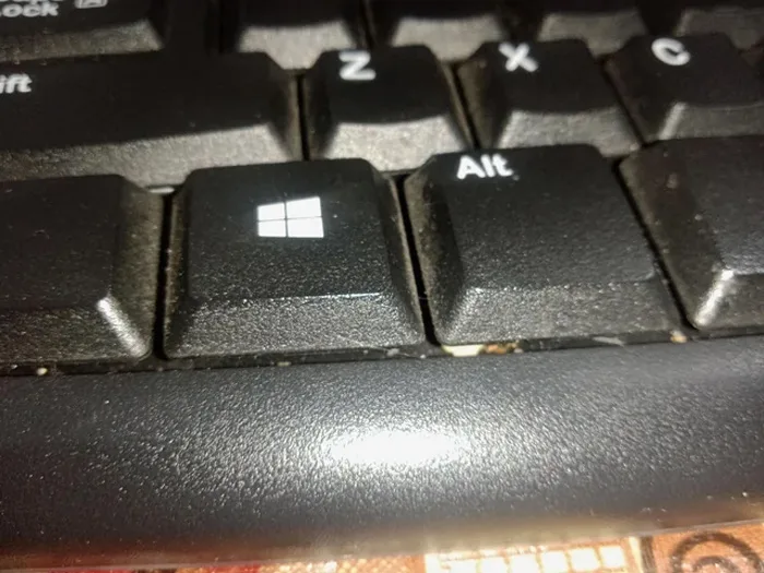 Dust and crumbs stuck between dirty keyboard keycaps