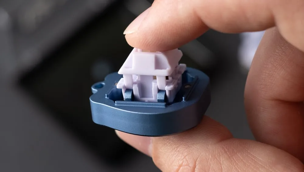 Fingers pressing the top housing back onto a switch sitting in a switch opener