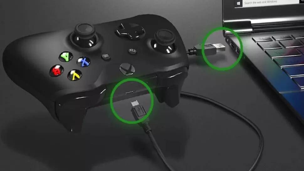 Xbox controller plugged into a laptop with a USB cable, both ends of the cable circled